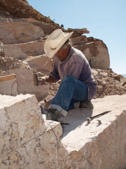 Worker hand-quarrying blocks of adoquin.