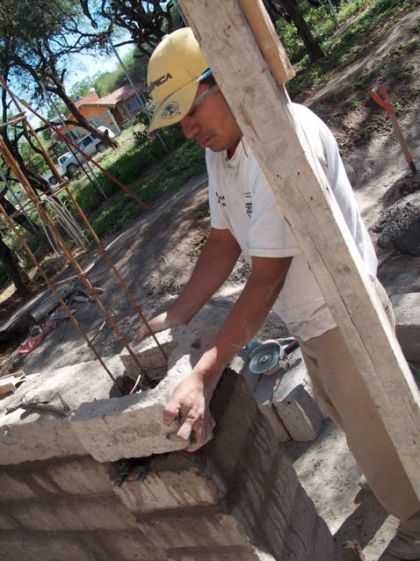 Manuel placing carved-out adobe blocks around castille forms. The garden wall won't be plastered, just like the large street-front wall, so concrete will be poured down the steel-enforced holes on these castilles, giving the wall hidden strength and structural integrity, yet allowing the raw beauty of the adobe to shine.